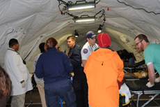 Medical personnel work inside the 748 square foot DRASH mobile field hospital.