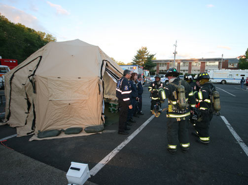 Firefighters congregate outside of a DRASH rehab shelter during the May 19 Eight Department fire drill.